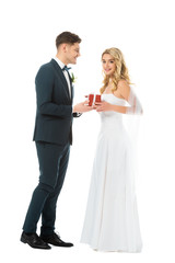 Wall Mural - smiling handsome groom presenting gift box to beautiful bride isolated on white