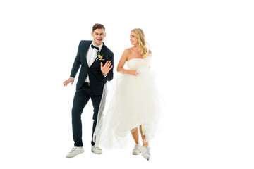 Wall Mural - happy couple dancing in elegant clothes and sneakers isolated on white