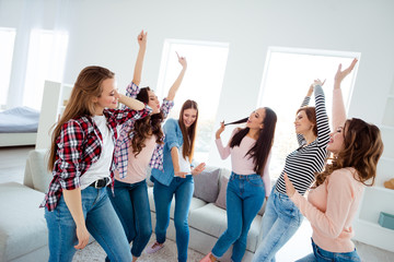 Poster - Nice shine graceful charming attractive cheerful cheery glad careless carefree girls wearing trendy casual clothes raising hands up rejoicing in light white interior room house indoors