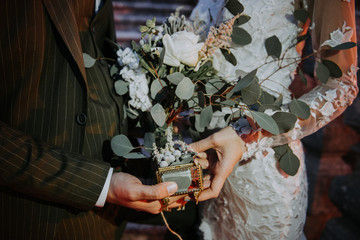 Wall Mural - Bride and Groom holding hands, and beautiful wedding ring on her hand. Romantic couple holding each other's hand at dinner in the garden.