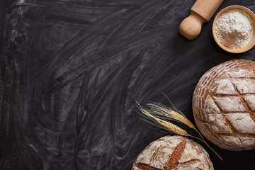 Bakery background. Homemade bread on a black background viewed from above. Top view. Copy space