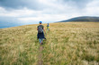© kivitimof - A girl walks along a mountain path in the Carpathians - view from behind.