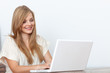 © gallofilm - Young woman using a notebook computer indoors
