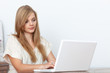 © gallofilm - Young woman using a notebook computer indoors