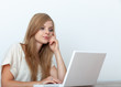 © gallofilm - Young woman using a notebook computer indoors