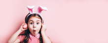 Cute Little Girl With Bunny Ears On Pink Background.