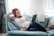 © leszekglasner - Pregnant woman relaxing on sofa reading book looking at belly