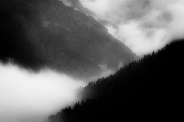 Wall Mural - Beautiful foggy sunset over the mountains alps in Sestriere ski resort, Italy. Creative black and white image.