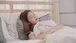 © tirachard - Asian woman dreaming while sleeping on bed in bedroom, Beautiful japanese female using relax time lying on bed at home. Lifestyle women using relax time at home concept.
