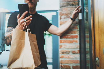 Courier delivery food service at home. Man courier delivered the order no name bag with food.