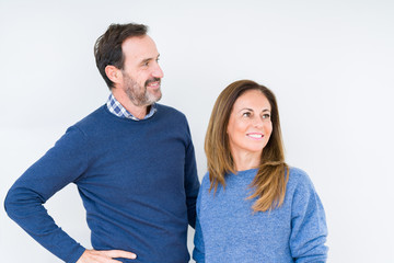 Poster - Beautiful middle age couple in love over isolated background looking away to side with smile on face, natural expression. Laughing confident.