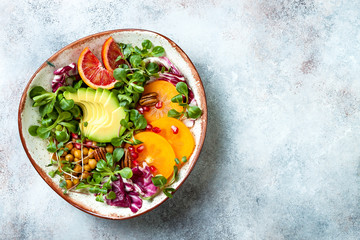 Wall Mural - Vegan, detox Buddha bowl with turmeric roasted  chickpeas, greens, avocado, persimmon, blood orange, nuts and pomegranate. Top view, flat lay, copy space