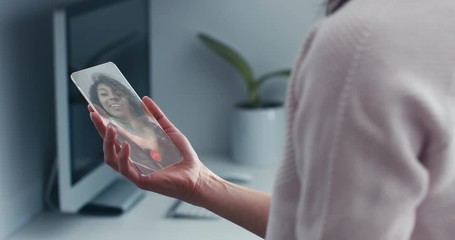 CU Caucasian female having a video call with an African American black woman using futuristic transparent phone. 4K UHD