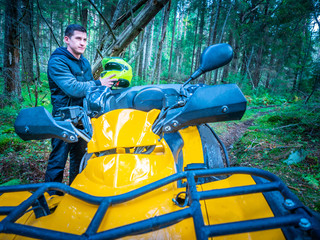 A man is preparing to go on the ATV. Riding an all-terrain vehicle. Riding a quad bike. Riding off-road on an ATV. Outdoor activity. Extreme. Rent a quad bike.