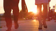 CLOSE UP: Cinematic shot of young colleagues in suits walking to work at sunrise