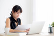 © NT_studio - Beautiful asian woman working and typing with laptop computer at office, businesswoman looking graph diagram analysis statistic data of finance, girl using notebook, profit growth, business concept.
