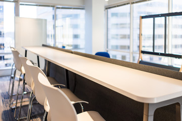 Wall Mural - Modern empty office room lunch kitchen bar in building with wooden corporate business table closeup by glass window and many row chairs nobody