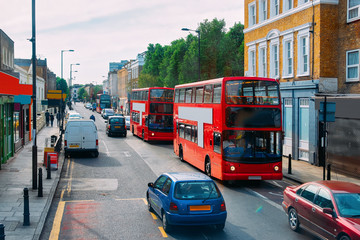 Red double decker bus on road in downtown street London