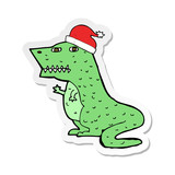 Fototapeta Dinusie - sticker of a cartoon dinosaur in christmas hat