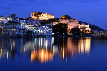 Fototapete - panoramic sunset view of city palace at Lake Pichola from Ambrai Ghat at Udaipur, Rajasthan, India