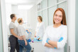 © Dmitry - Young beautiful woman doctor stands against the background of patients in the clinic. Patients married couple, woman pregnant