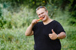© Vladimir - very fat guy eats carrots after training in the park in summer