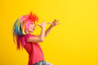 © Pixel-Shot - Funny little girl in wig on color background. April fools' day celebration