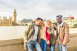 Happy multiracial friends group using smartphone in London