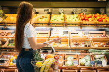 Female Customer Against Fruit Section In Food Store