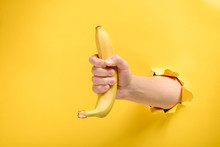 Hand Giving A Ripe Banana