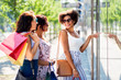 © Syda Productions - sale, consumerism and people concept - happy young women with shopping bags pointing finger to shop window in city