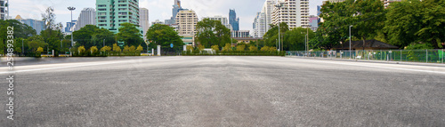 Leinwand Poster  Empty asphalt road with city in the background