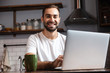 © Drobot Dean - Photo of mature man using silver laptop while sitting at table in modern apartment