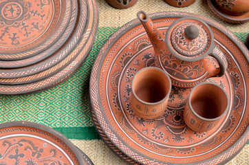 Wall Mural - Top view closeup of beautiful Gujarati Khavda Pottery earthen terracotta crockery tea cups kettle and tray at a roadside market exhibition stall at Dilli Haat, New Delhi India International trade fair