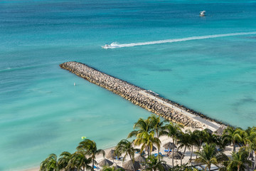 Wall Mural - Recreation boats in front of beach with blue waters and white sands with coconut trees .Aruba