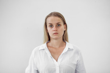 Portrait of a tired girl without makeup on a white background