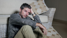 Lifestyle Portrait Young Attractive Sad And Depressed Man Sitting On Living Room Floor Feeling Desperate And Stressed Suffering Depression And Anxiety Problem Looking Frustrated