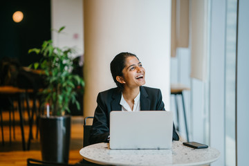 Wall Mural - A wonderful Indian lady respecting a partner while in a talk. She is grinning before an associate while chipping away at a PC.