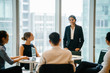 © Danon - An Asian Indian businesswoman is having a conversation with her colleagues in a conference room and looking forward for their project. She's wearing a black blazer and white blouse with a black skirt.