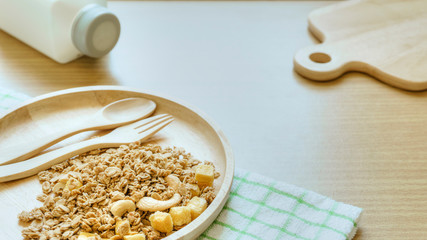 Close up granola bowl with a wooden spoon and plate on a wood table background. Top view. isolated in white. Concept for healthy food. Flat lay.