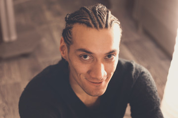 male hairstyle close-up braids, hair braided, pensive look, man portrait