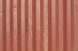 red container wall with rust spots and dents