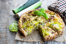 Leek Tart With Bacon And Cheese On Wooden Table