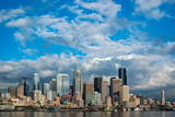 Fototapeta Miasto - Beautiful Sunny Day in Seattle, Washington. The Seattle skyline as seen from the Bainbridge Island ferry. Puffy clouds and blue sky make for a perfect day in the Puget Sound area.