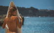 topless young woman holding surfboard in front, gorgeous naked back of slim girl