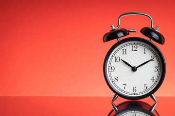 Alarm Clock on red background with selective focus and crop fragment. Business and Copy space concept