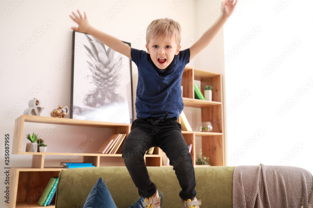 Happy little boy jumping at home