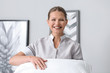 Beautiful female housekeeper with soft pillow in room