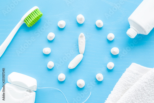 Fotomural Toothbrush, white tube of toothpaste, dental floss and towel on pastel blue background