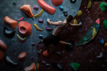 Athletic man practicing in a bouldering gym